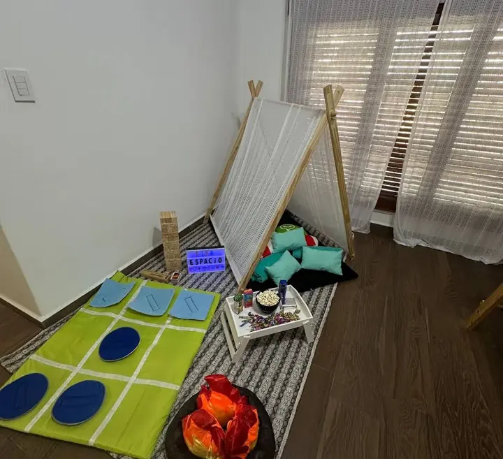 Carpita de pijamada con almohadones y juegos